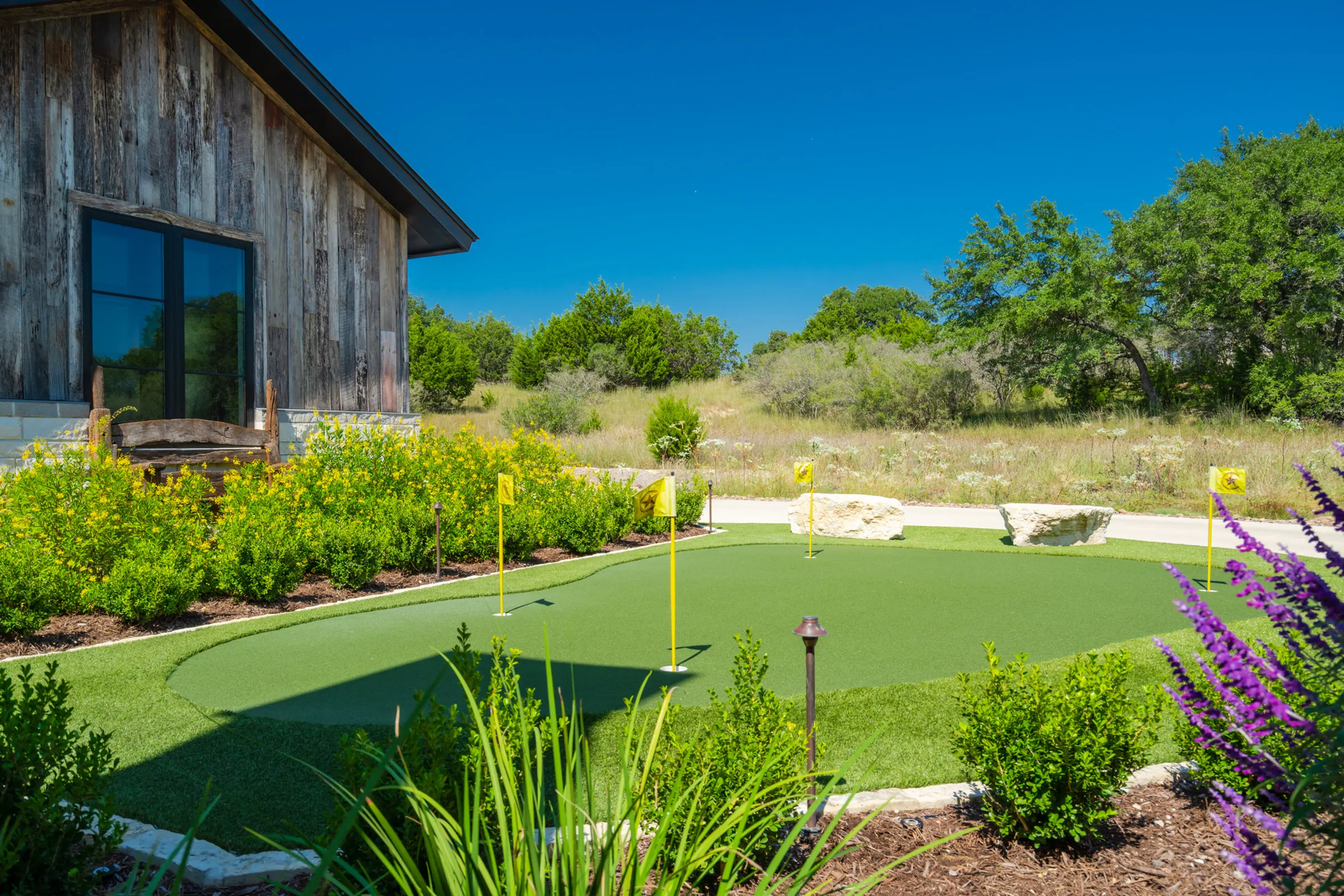Natural putting green framed by native planting beds