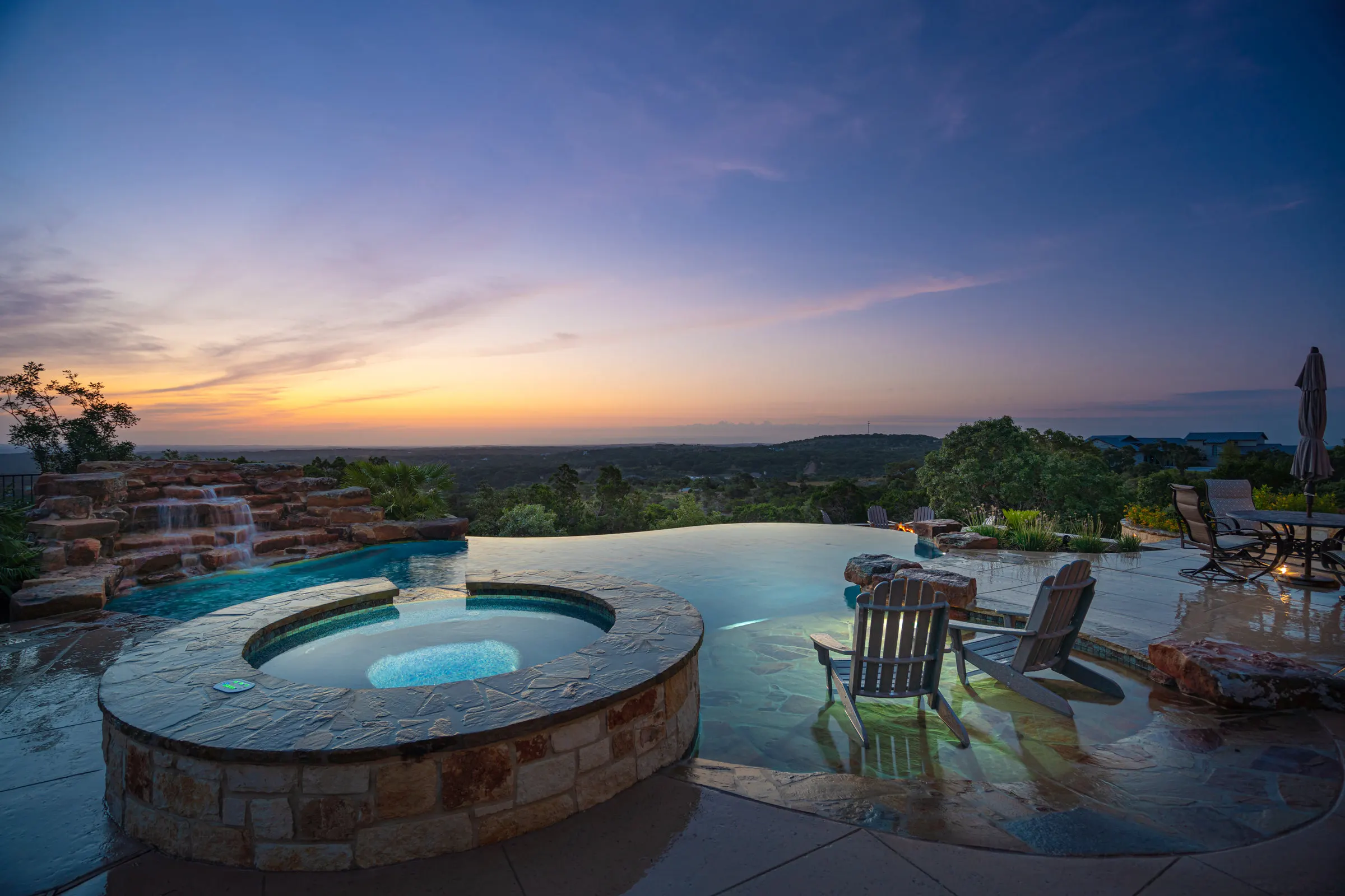 Vanishing edge pool and round spa at sunset in the Texas Hill Country