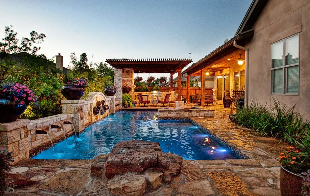 Pool, pergola and outdoor kitchen at dusk
